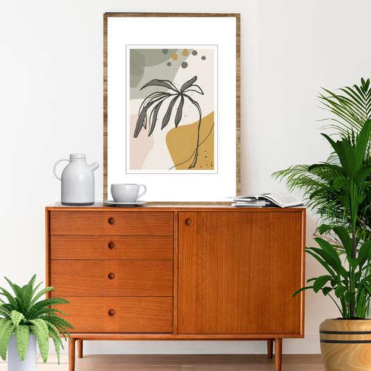 Abstrakt grafisk motiv med tropiske blader i fargenyanser sort, oker, rosa, grå og beige. Plakaten har hvit kantlinje. For innramming eller på lerret.