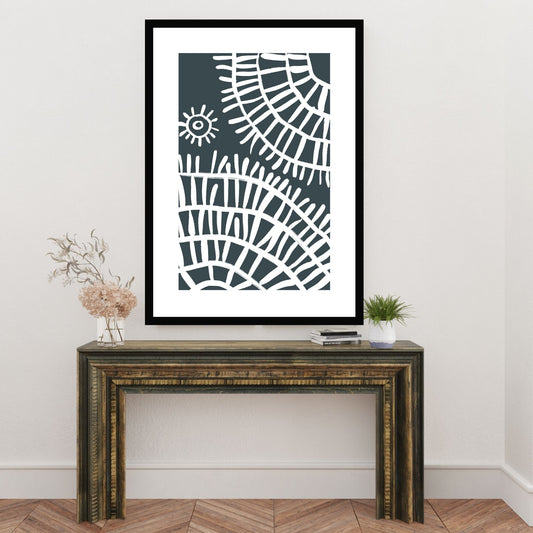 Plakat i abstrakt grafisk motiv i hvit dekor og mørk blå/grå bunnfarge. Plakaten har en hvit kant som gir dybde, og fremhever motivet. Illustrasjonen viser plakat i sort ramme som henger på en vegg over en liten skjenk.