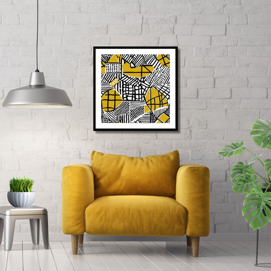 Kvadratisk plakat med abstrakt mønster i fargene oker, sort og hvit. Det er en hvit kant rundt plakaten. Her er den rammet inn i sort ramme, og henger på en hvit murvegg. Det henger en grå pendellampe og det står en gul stol under bildet.