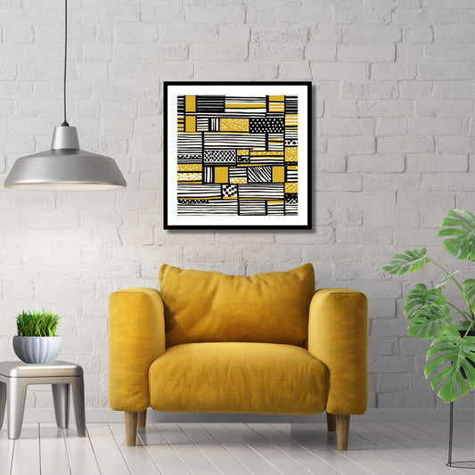 Kvadratisk plakat med abstrakt mønster i fargene oker, sort og hvit. Det er en hvit kant rundt plakaten. Her er den rammet inn i sort ramme, og henger på en hvit murvegg. Det henger en grå pendellampe og det står en gul stol under bildet.