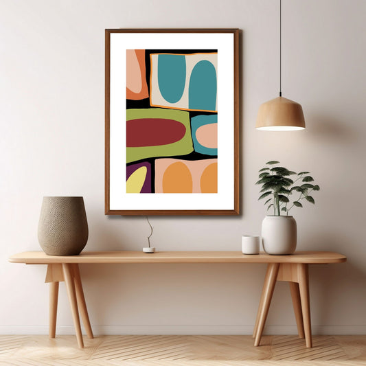 Plakat med et dekorativt, grafisk motiv med harmoniske farger i gult, oransje, dempet grønn, petrol, rosa, burgunder, beige og sort. Plakaten har en hvit kant som gir mer dybde og fremhever motivet. Illustrasjonen viser plakaten henge i en eike ramme.