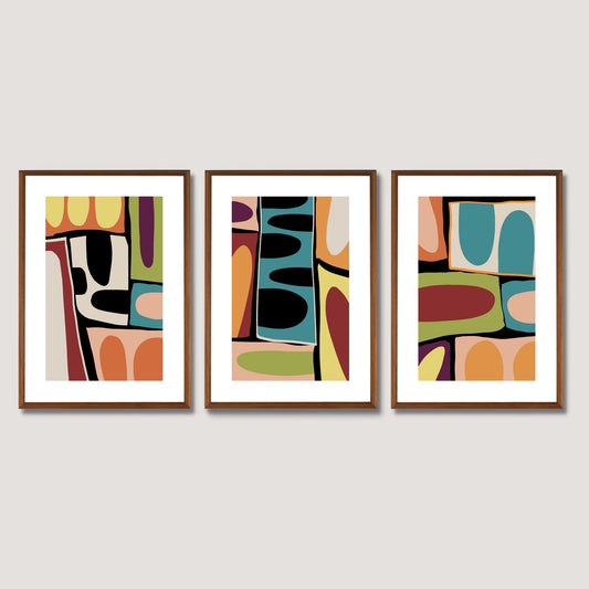 En serie plakater med dekorative, grafiske motiv med harmoniske farger i gult, oransje, dempet grønn, petrol, rosa, burgunder, beige og sort. Plakatene har en hvit kant som gir mer dybde og fremhever motivet. Illustrasjonen viser hele serien i eikerammer som henger på en vegg.