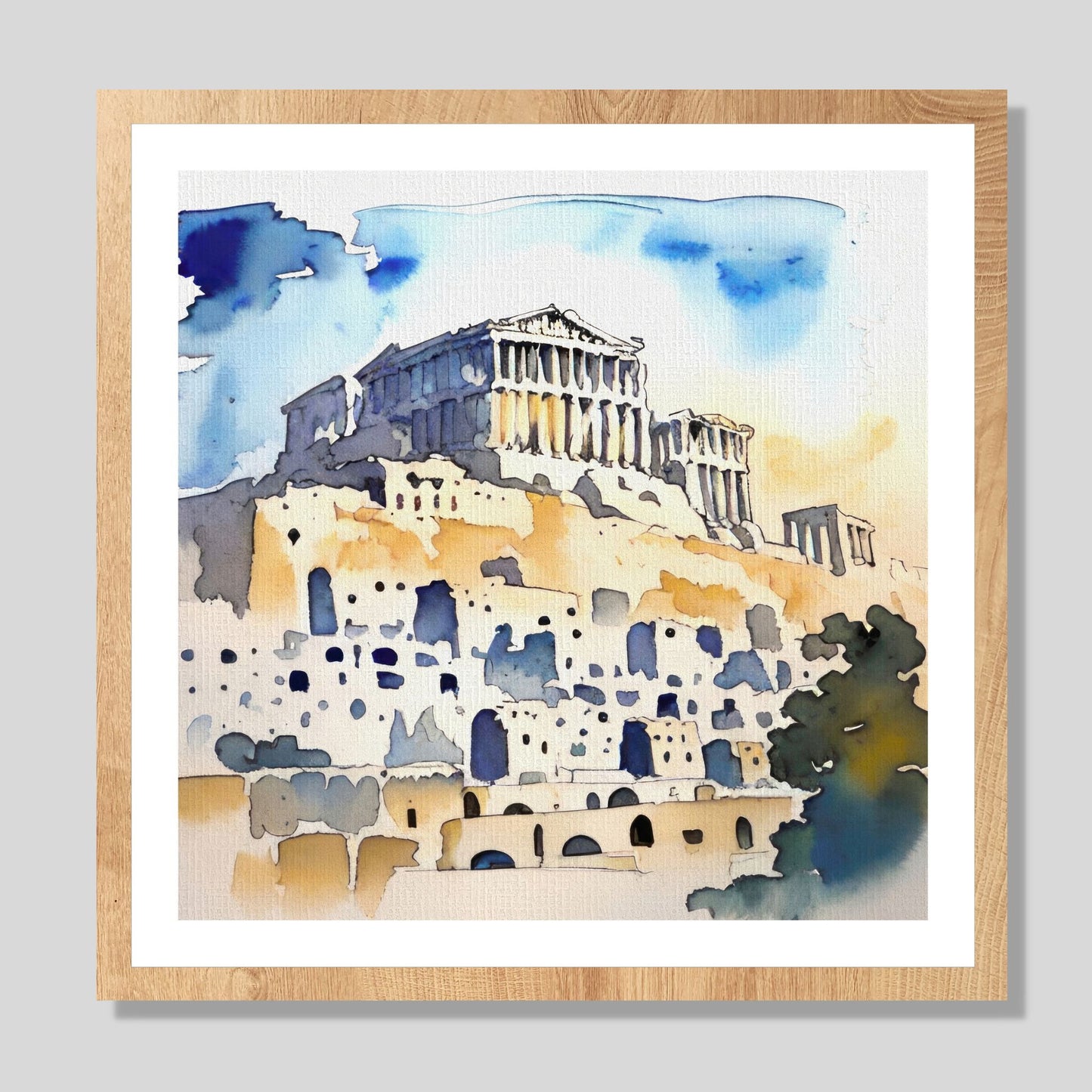 Kvadratisk akvarell i grafisk trykk av Akropolis. Motivet er i duse vannfarger i blått, hvitt, beige og mørk grå. På bildet er motivet rammet inn i eikeramme, og henger på lerret på en lys vegg.
