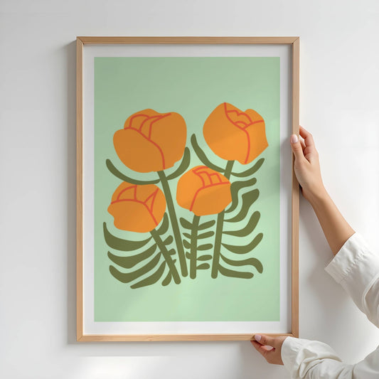 Bold Botanical No2 viser fire stiliserte, oransje blomster med røde linjedetaljer strekker seg opp fra et tett, mørkegrønt bladverk. Det hele balanseres mot en myk, lysegrønn bakgrunn som løfter fram fargenes varme og rytmen i komposisjonen. Et frodig og energisk blomsterbilde med grafisk sjarm. Illustrasjon viser plakat i eik ramme.