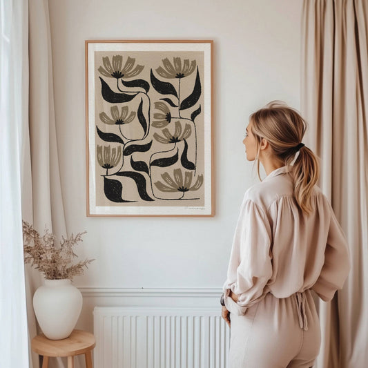 Botanisk Eleganse har en harmonisk fargepalett i jordnære beige- og brunsjatteringer, kombinert med dype svarte kontraster som skaper et stilrent og tidløst botanisk uttrykk. Illustrasjon viser plakat i eik ramme.