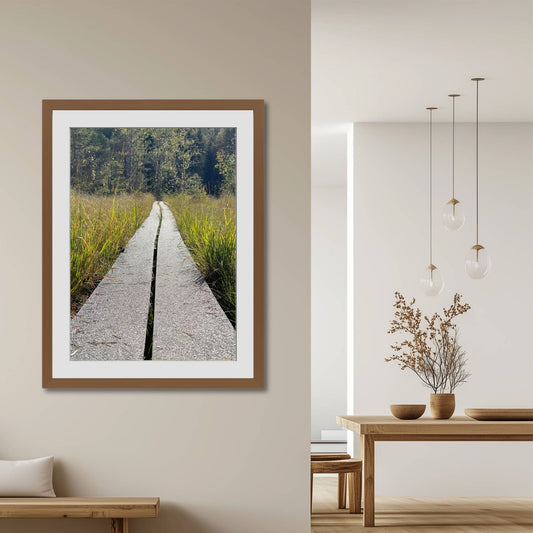 Plankestien – Veien gjennom Myra er et motiv med perspektiv og symbolikk. Illustrasjon viser motivet som plakat med passepartout i brun ramme.