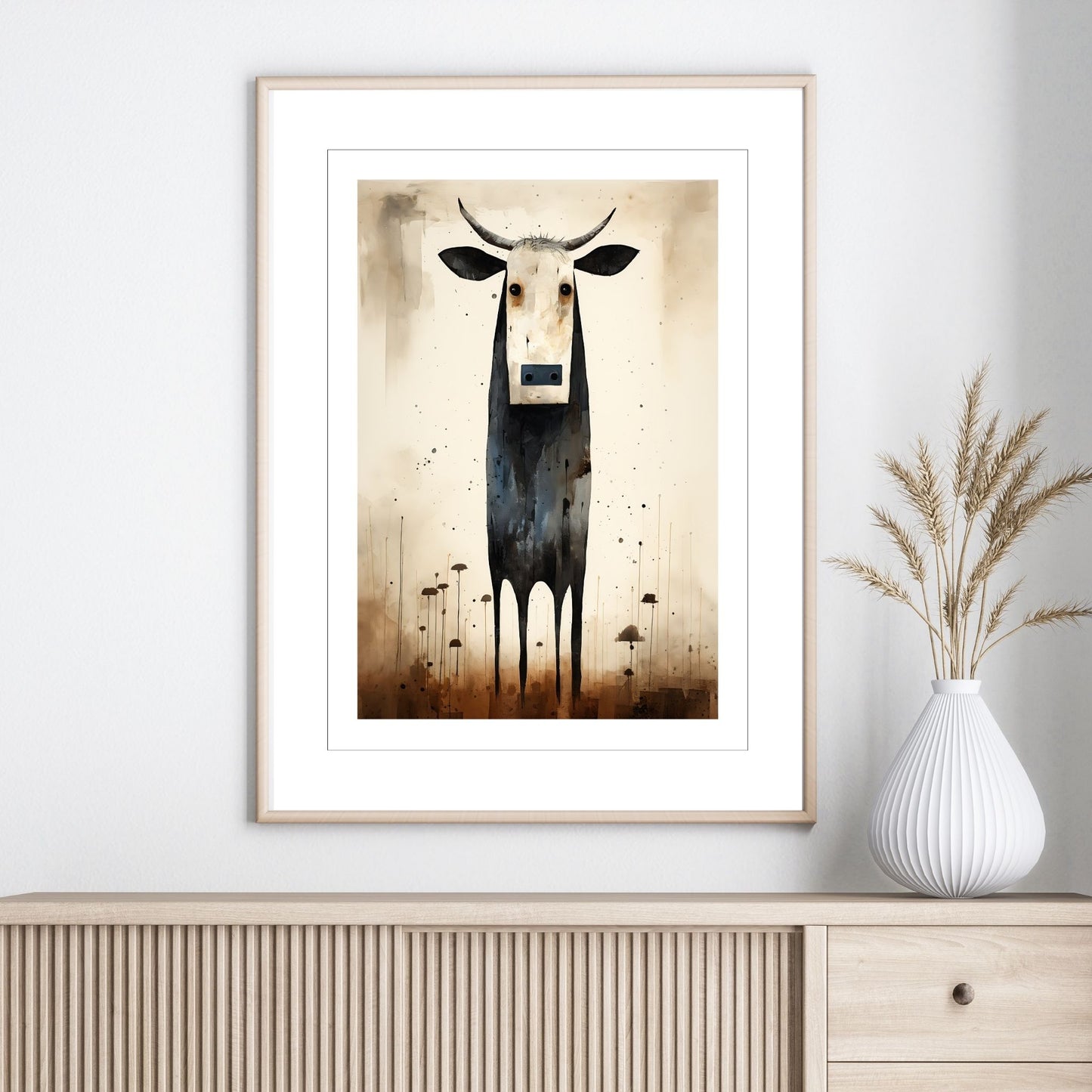Grafisk maleri av en ku med sort kropp og hvitt ansikt, satt mot en varm beige bakgrunn. illustrasjonen viser motivet som plakat i en ramme.