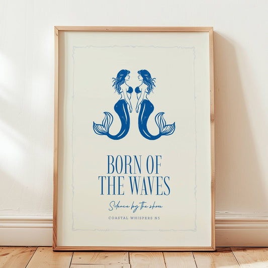 Coastal Whispers No5 – Plakat. To speilvendte havfrueri blått med teksten Born of the waves. Et rolig og poetisk motiv med maritim sjel og symmetrisk eleganse. Illustrasjon viser plakat i eik ramme.
