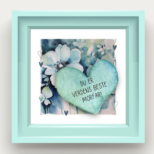 Grafisk plakat med et lyseblått hjerte påført tekst "Du er verdens beste pappa!". Bagrunn med blomster i blåtoner. Illustrasjon som viser plakat i lyseblå ramme.