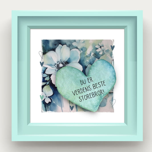 Grafisk plakat med et lyseblått hjerte påført tekst "Du er verdens beste storebror!". Bagrunn med blomster i blåtoner. Illustrason viser plakat i lyseblå ramme.