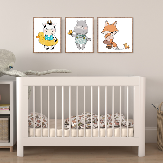 Grafiske motiver av dyrefigurer i eikerammer hengt over seng på barnerom.