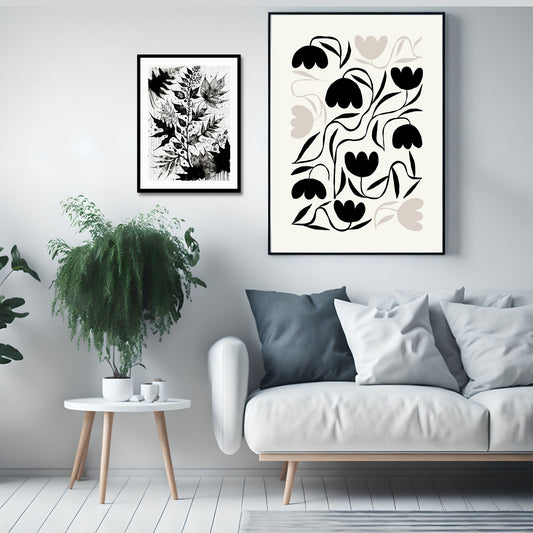Miljøbilde som viser grafisk plakat i abstrakt, floralt mønster i sort, beige og dempet hvit bakgrunn. Plakaten har et bredt felt rundt i bakgrunnsfarge, og henger i sort ramme på en lys vegg over en blå sofa. Ved siden henger en plakat i serien «Ink Floral» fra Postergalleriet.