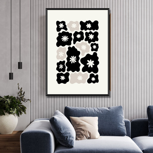 Illustrasjon av en grafisk plakat i abstrakt, floralt mønster i sort, beige og dempet hvit bakgrunn. Plakaten har en bred kant i samme som bakgrunnsfarge, og henger i sort ramme på en vegg over en sofa.