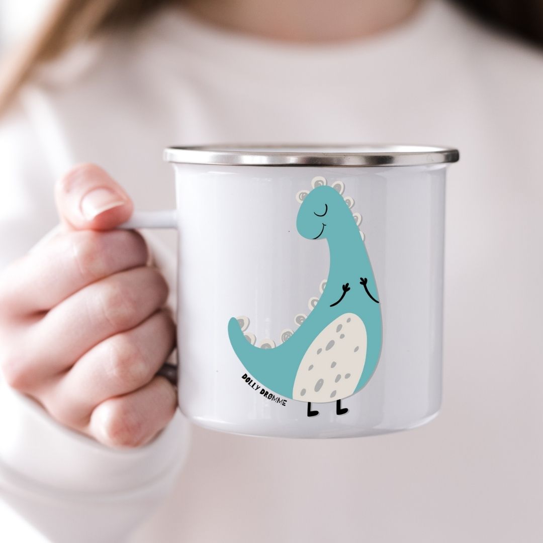 Barn som holder emaljekrus med motiv av dinosauren Dolly Drømme fra Dino Venneflokken