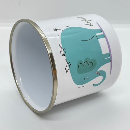 Emaljekrus i hvit farge med håndtak og en dekorativ sølvkant øverst. Kruset er påført et trykk med en grønn Elefant. Volum 32 cl. Diameter 8 cm. Høyde 8 cm.