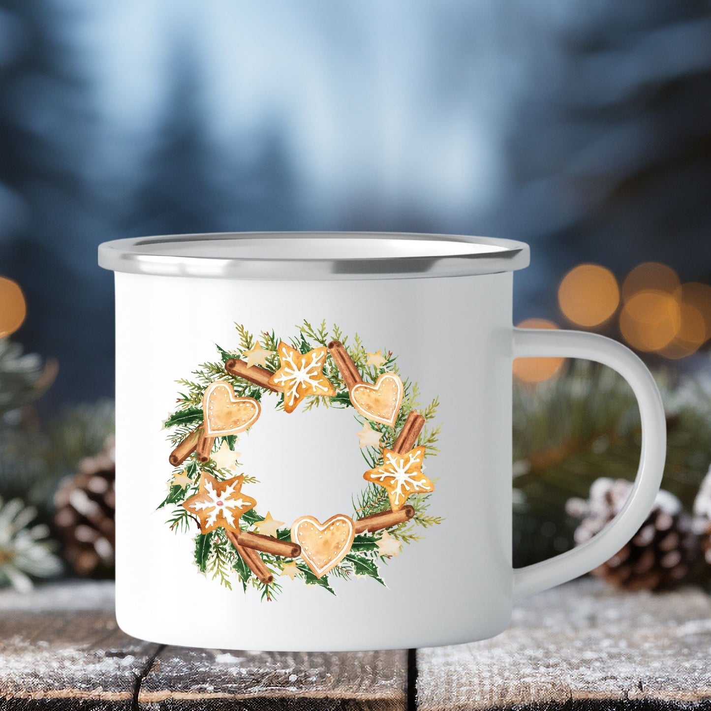 Emaljekrus i hvit farge med en dekorativ sølvkant øverst. Kruset er påført to dekorative julemotiver, en på hver side av koppen. Dette er en lett, uknuselig kopp på 138 gram. Bildet viser den ene siden av julekruset med et julemotiv av en krans av bar pyntet med pepperkaker og kanelstenger.