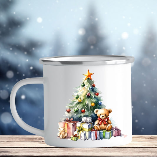 Emaljekrus i hvit farge med en dekorativ sølvkant øverst. Kruset er påført to dekorative julemotiver, en på hver side av koppen. Dette er en lett, uknuselig kopp på 138 gram. Bildet viser den ene siden av julekruset som er dekorert med et julemotiv av juletre og julepakker. På en av pakkene sitter en liten bamse.