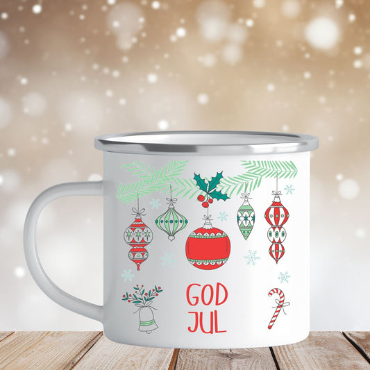 Emaljekrus i hvit farge med en dekorativ sølvkant øverst. Kruset er påført to dekorative julemotiver, en på hver side av koppen. Dette er en lett, uknuselig kopp på 138 gram. Bildet viser en side av kruset med et dekorative håndtegnet julefigurer.