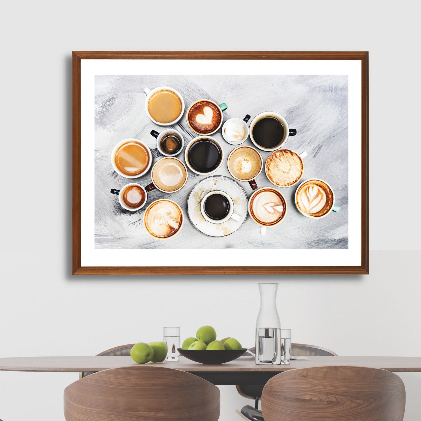 Dekorativ plakat av 15 ulike kopper kaffe som vil passe perfekt på en kjøkkenvegg. Plakaten har en hvit kant som gir bildet mer dybde og fremhever motivet. Illustrasjonen viser plakaten i eikeramme på en vegg over et spisebord.