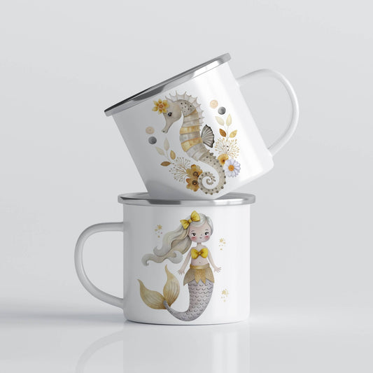 EVENTYRKRUS No22 – havfrue og sjøhest i gylne toner. Et drømmende krus med gyllen havfrue på den ene siden og en elegant sjøhest omgitt av blomster og bobler på den andre.