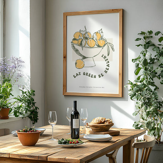 Mandariner i skål med teksten "Eat green, be here" gir et hverdagsfilosofisk og samtidig fargerikt uttrykk. Illustrasjon viser plakat i eik ramme.