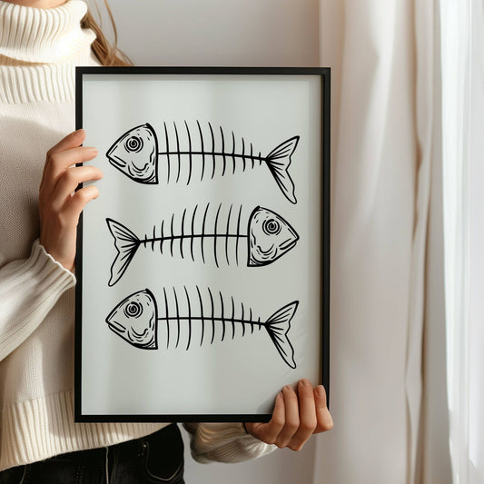FISKEBEIN – grafisk plakat er en humoristisk og moderne illustrasjon med tre stiliserte fiskeskjelett, gjengitt i sort strek på lys bakgrunn. Illustrasjon viser plakat i sort ramme.