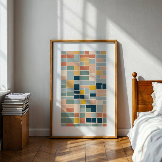 Geo Harmony består av rektangulære former i myke, balanserte fargetoner som blå, grønn, gul og terrakotta. Illustrasjon viser plakat i eik ramme på gulv.