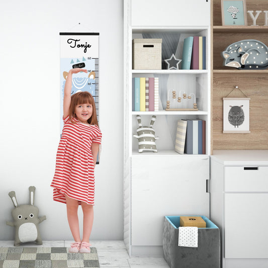 Dekorativ plakat med høydemåler med en dus blå sau på lyse blå bakgrunn. Illustrasjon som viser høydemåler henger på en vegg og en jente måler seg.