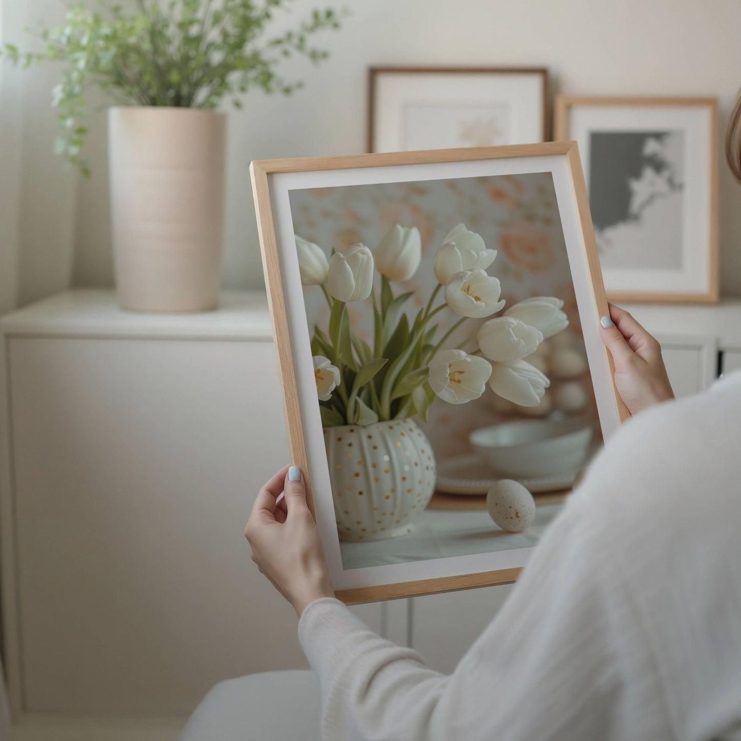 Bildet viser en rund, hvit vase fylt med hvite tulipaner og gullprikker, en perfekt påminnelse om sesongens blomstring. illustrasjon viser plakat med hvit kant i eik ramme.