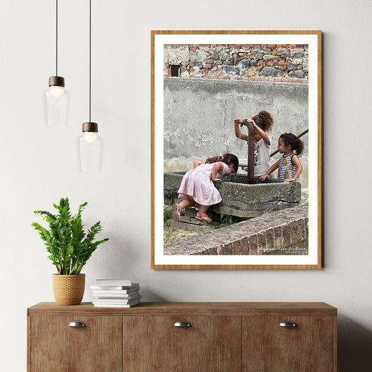 Det er en varm sommerdag i Piemonte. Tre små jenter i sommerkjoler drikker vann og avkjøler seg i vannfontenen i Grinzane Cavour.