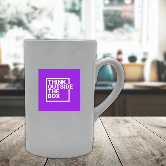 Krus i hvit keramikk med håndtak. Kruset er påført teksten "Think outside the box" Hvit farge på tekst og lilla dekorelement.