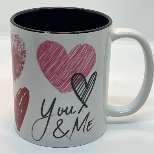 Krus i keramikk med en stilfull design fylt med håndtegnede hjerter og de kjærlige ordene "I love you" og "You & Me".