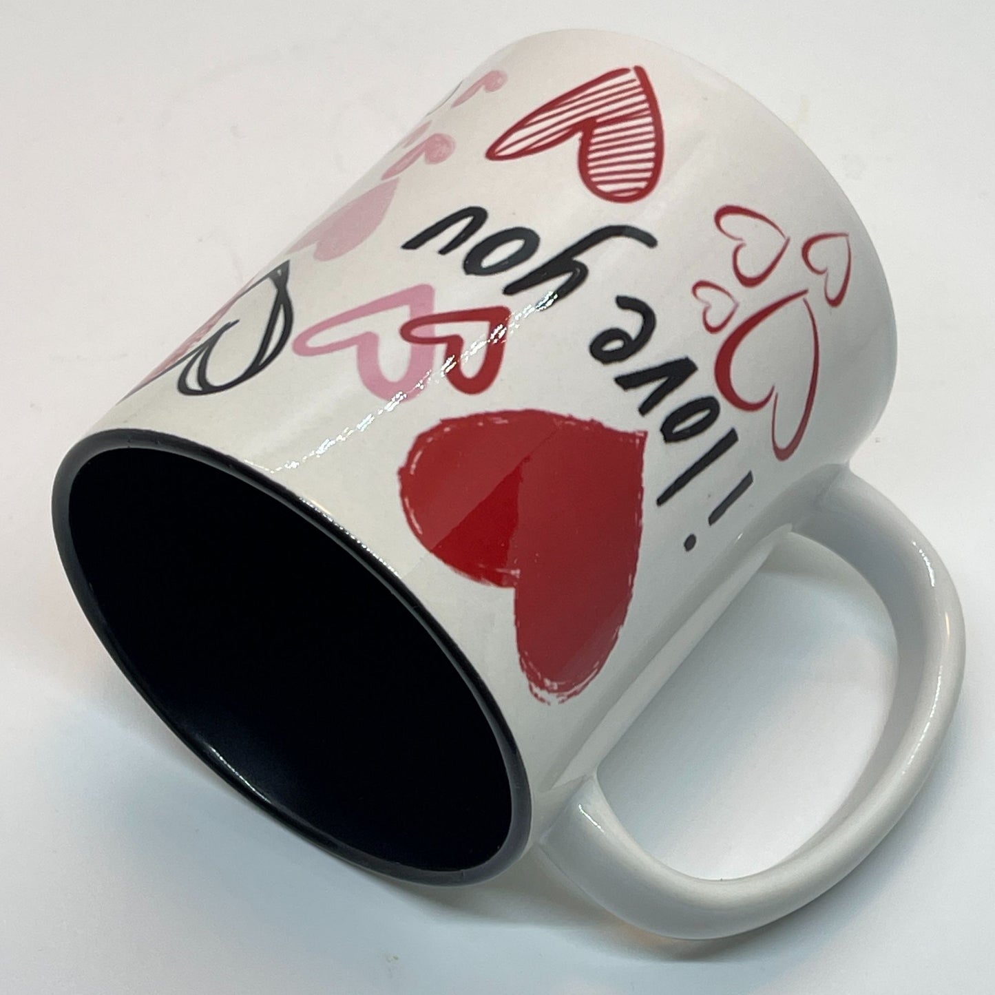 Krus i keramikk med en stilfull design fylt med håndtegnede hjerter og de kjærlige ordene "I love you" og "You & Me".