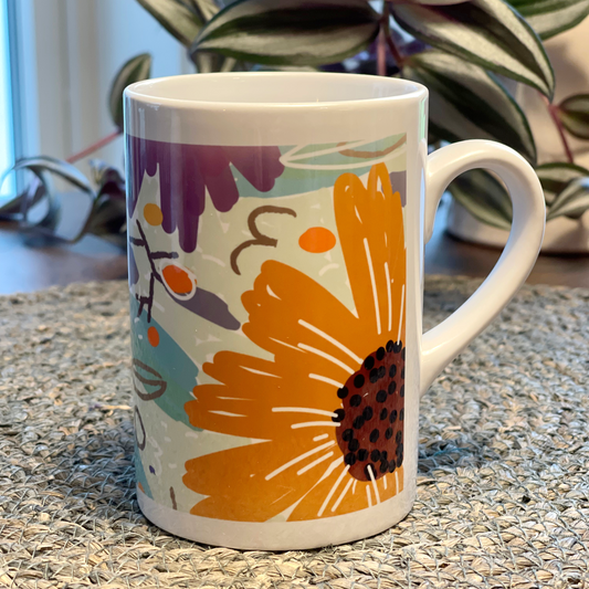 Hvitt krus i keramikk med håndtak. Kruset er påført et multifarget floralt trykk. Volum: 29 cl. Diameter: 7 cm. Høyde: 10,5 cm.