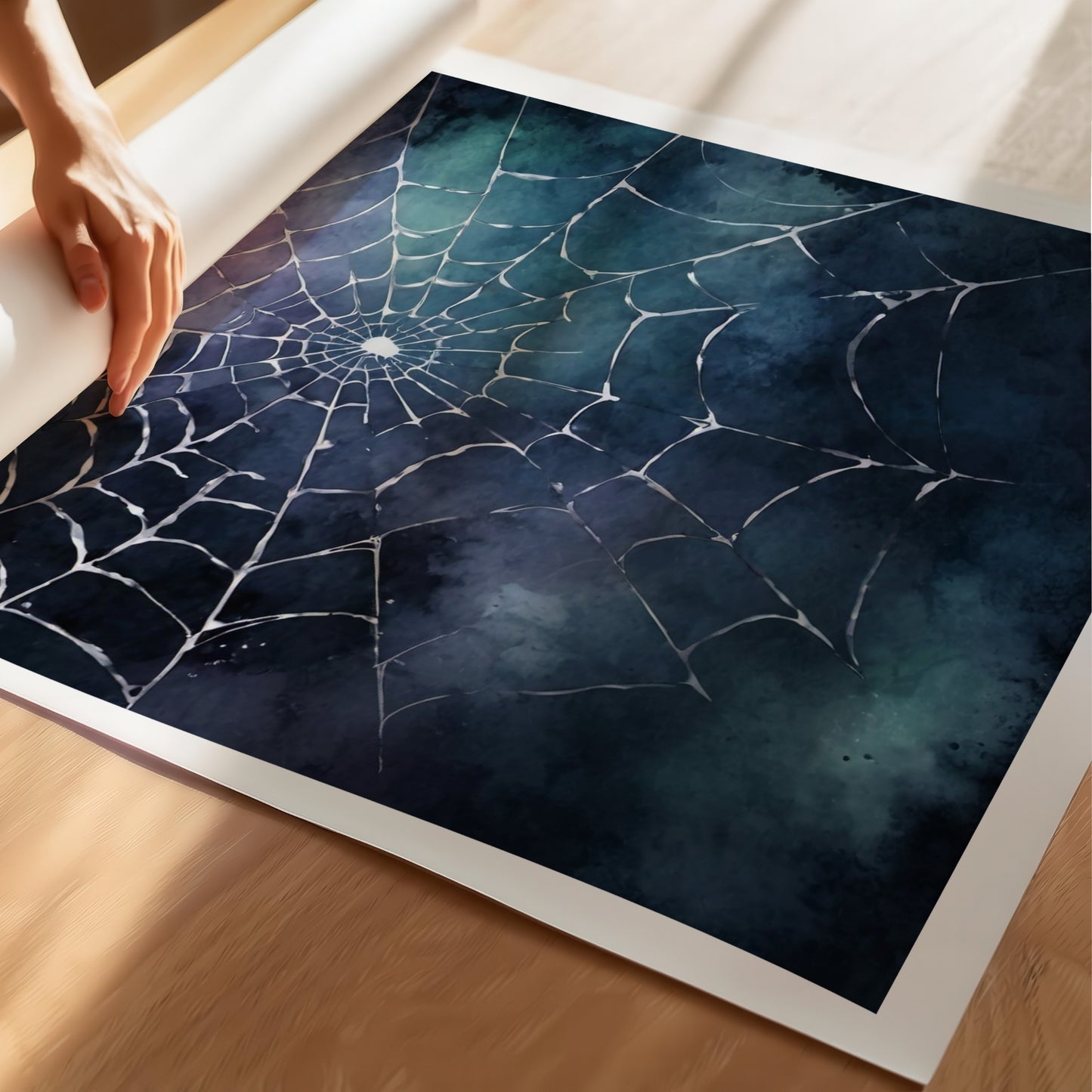“Midnight Web” er en stemningsfull Halloween-plakat som viser et delikat edderkoppnett mot en mørk, tåkete bakgrunn i blå, lilla og grønne nyanser. illustrasjon viser plakat på print.