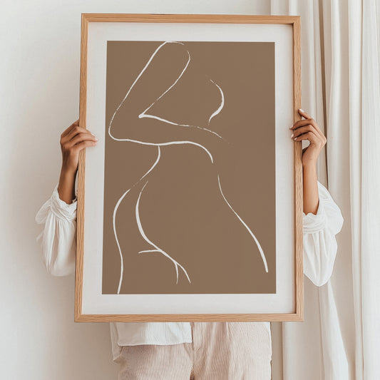 Dette elegante kunstverket fremhever en abstrakt silhuett av en kropp, tegnet med rene hvite linjer mot en bakgrunn i varme jordtoner. Illustrasjonen viser plakat med passepartout i eik ramme.
