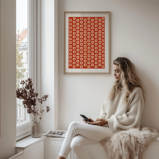 Dette unike designet kombinerer rustrøde toner med organiske, håndtegnede beige ruter som gir en leken og samtidig sofistikert estetikk. Illustrasjon viser plakat med passepartout i ramme av eik.