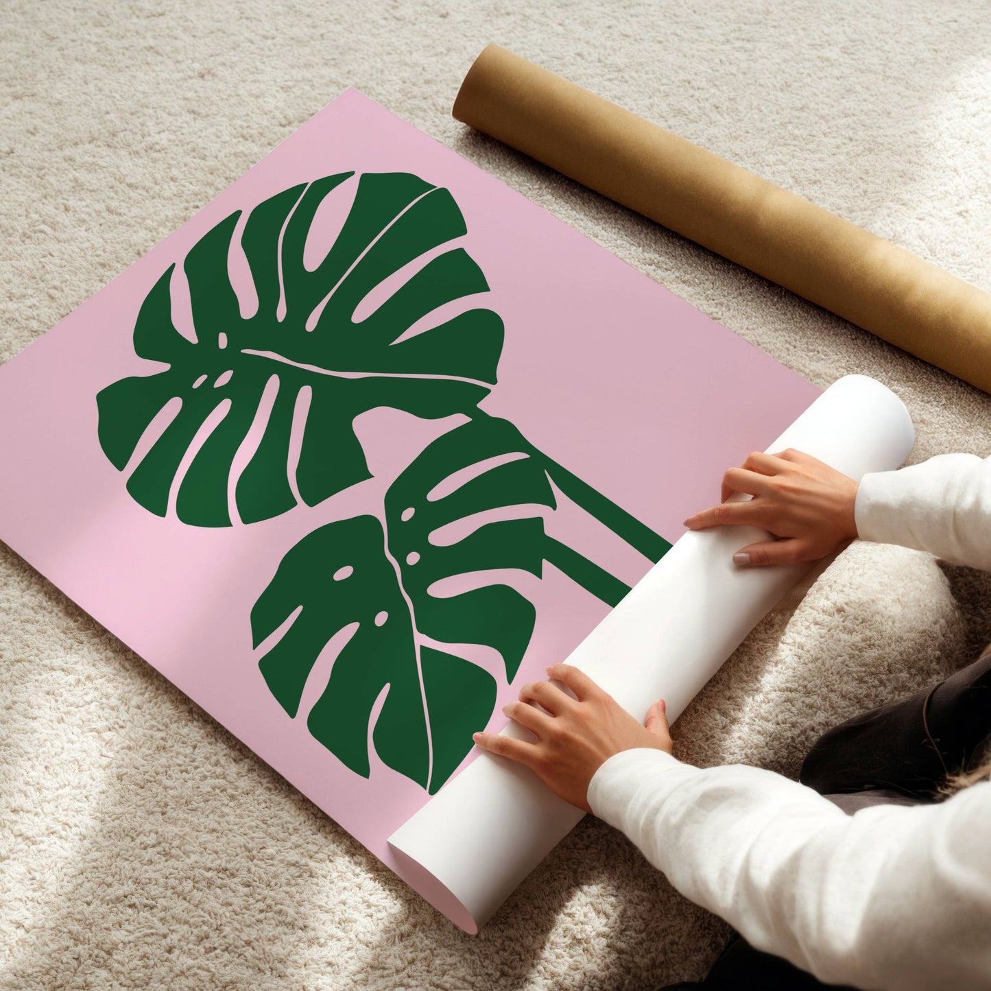 Monstera Blush – en minimalistisk og trendy botanisk plakat med to ikoniske monstera-blader i dyp grønn mot en myk rosa bakgrunn. Illustrasjon viser plakat på print.