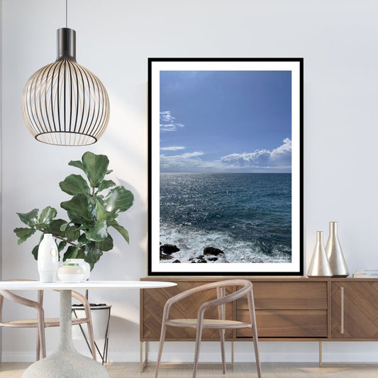 Motiv av Middelhavet ved Montereosso al Mare, en av de fem byene i Cinque Terre ved Liguriakysten i Italia. Bildet viser det blåe Middelhavet og himmel som møtes i horisonten. Dønninger fra havet skaper bølger ved land. Her er plakaten er satt inn i sort ramme. Bildet har en hvit kant rundt.