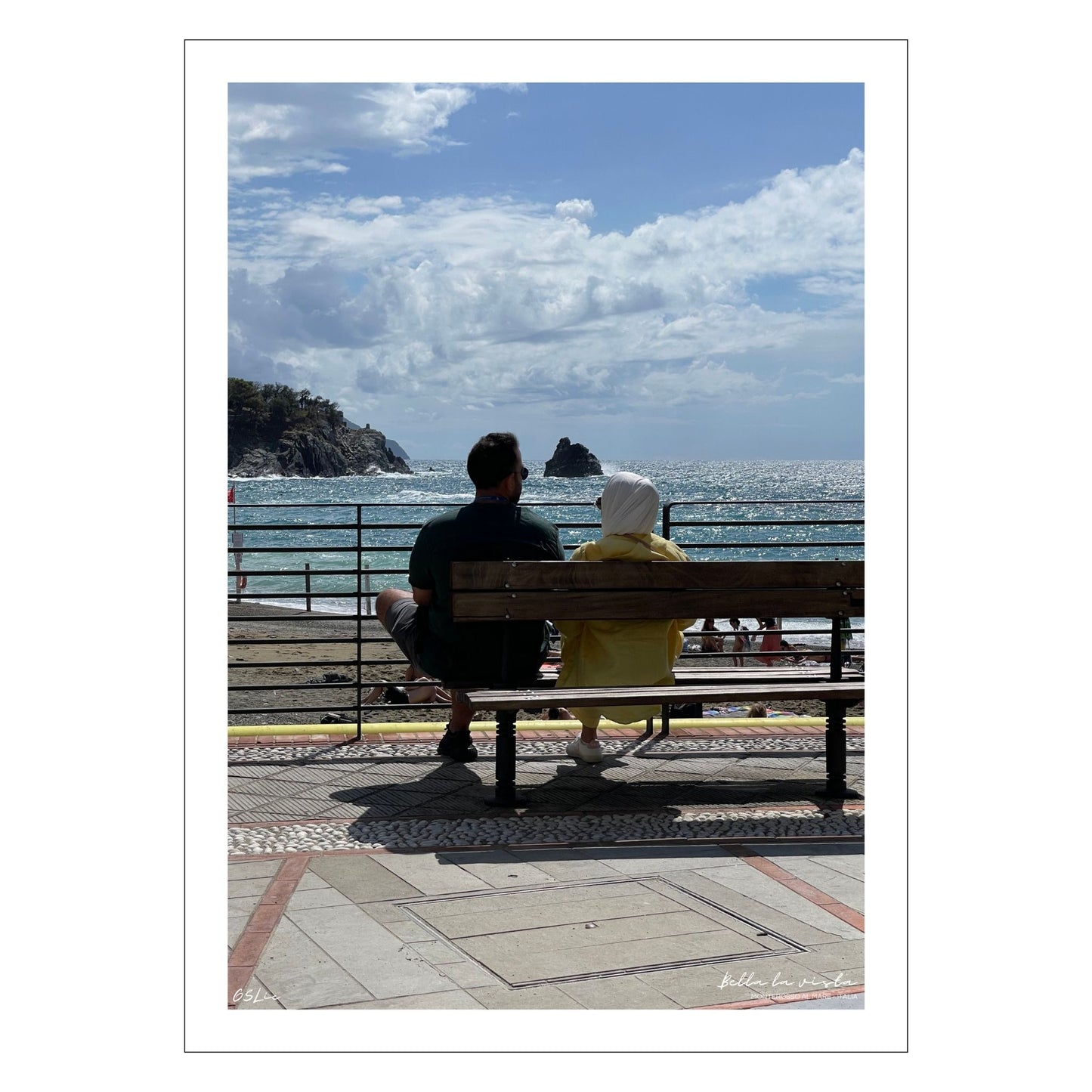 Motiv fra Montereosso al Mare, en av de fem byene i Cinque Terre ved Liguriakysten i Italia. Bildet viser blått middelhav og himmel som helt ned i vannet i horisonten. Her har et par funnet seg godt til rette på en av byens benker. Fri sikt utover Middelhavet så langt øyet ser. Til venstre på bildet går klipper ned i havet. Blå himmel er dekket med noen hvite skyer. Hav og himmel møtes ute i horisonten.