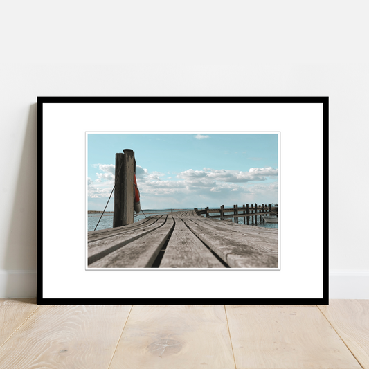 Gammel brygge, sjø, blå himmel og hvite skyer ved Saltholmen, Saltnes. Vakkert norsk kystlandskap i Østfold som vil være dekorativ på en fotoplakat.