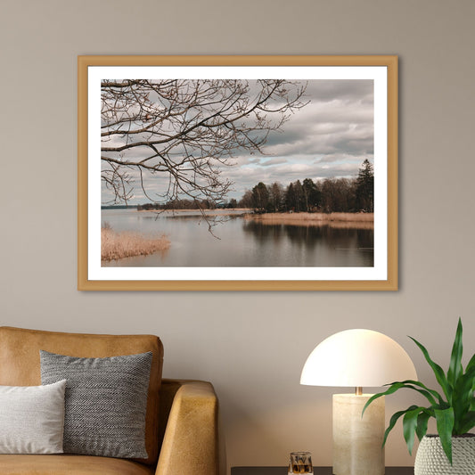 Dykk inn i en verden av sublim natur og opplev øyen Tidö-Lindös magi i april. Vårt unike bilde fanger øyeblikket av en vakker utsikt over vann, siv og holmer ved Mälaren. Illustrasjon som viser motivet som plakat i en ramme av eik.