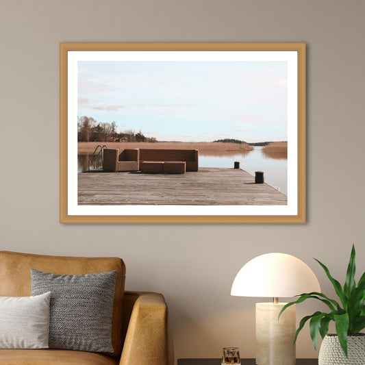 Dykk inn i en verden av sublim natur og opplev øyen Tidö-Lindös magi i april. Vårt unike bilde fanger øyeblikket av en privat brygge med en lounge guppe ved Mälaren. Illustrasjon som viser motivet som plakat i en ramme av eik.