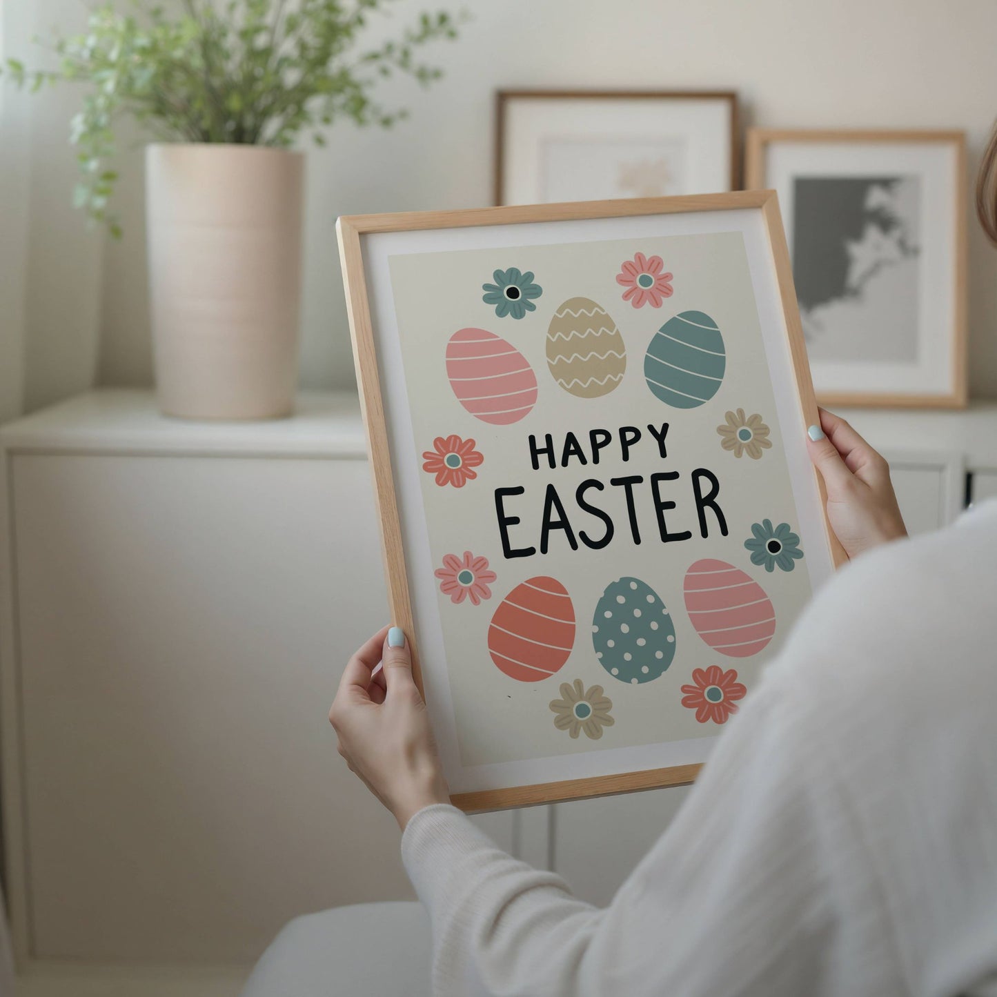 Denne stemningsfulle påskeplakaten har et sjarmerende design med fargerike påskeegg og blomster, perfekt for å skape en lun og festlig påskestemning. Illustrasjon viser plakat med hvit kant i eik ramme.