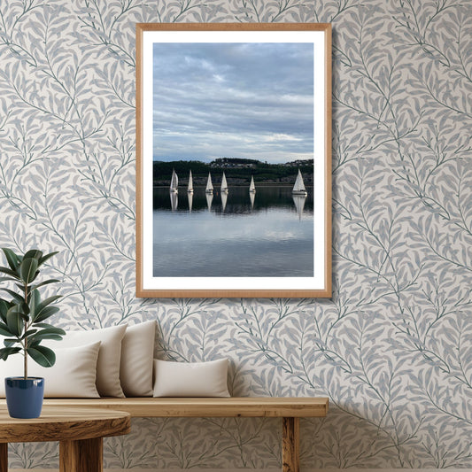 Båtene speiles perfekt i fjorden, omkranset av mørke åser og kveldshimmel. Dette er et elegant og avbalansert motiv som formidler både bevegelse og stillhet – ideelt for sjø- og seilentusiaster. Illustrasjon viser motivet som plakat med hvit kantlinje i eik ramme.