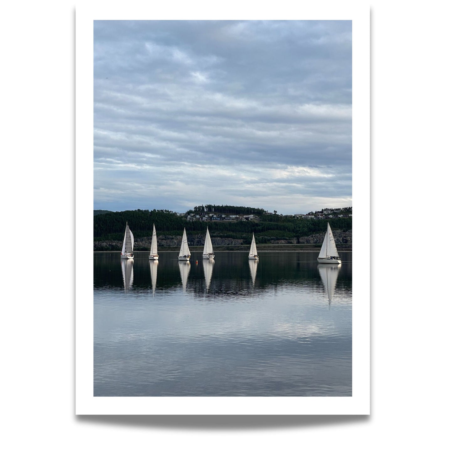 Båtene speiles perfekt i fjorden, omkranset av mørke åser og kveldshimmel. Dette er et elegant og avbalansert motiv som formidler både bevegelse og stillhet – ideelt for sjø- og seilentusiaster.