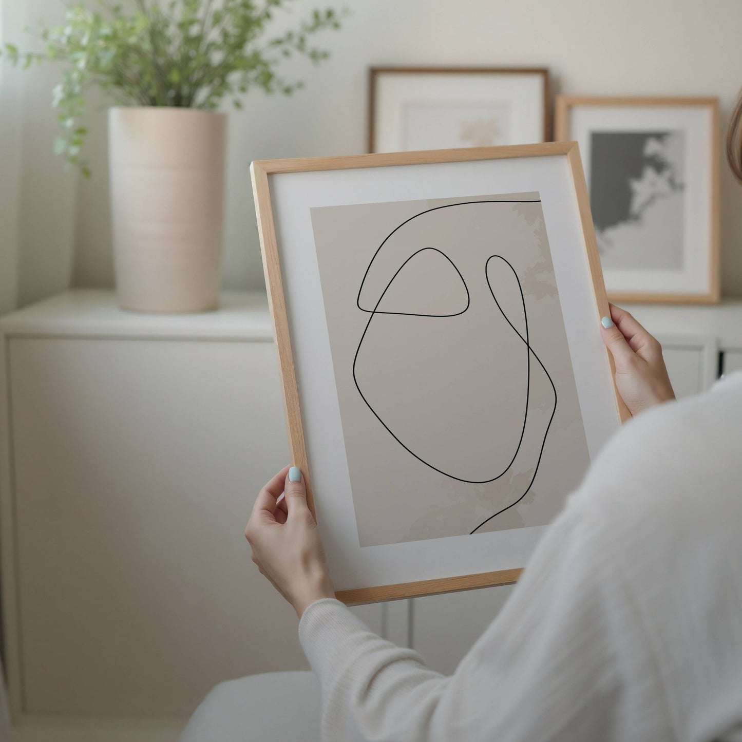 Soft Flow – minimalistisk linjekunst plakat er et harmonisk møte mellom enkelhet og uttrykk. Illustrasjon viser plakat i eik ramme.