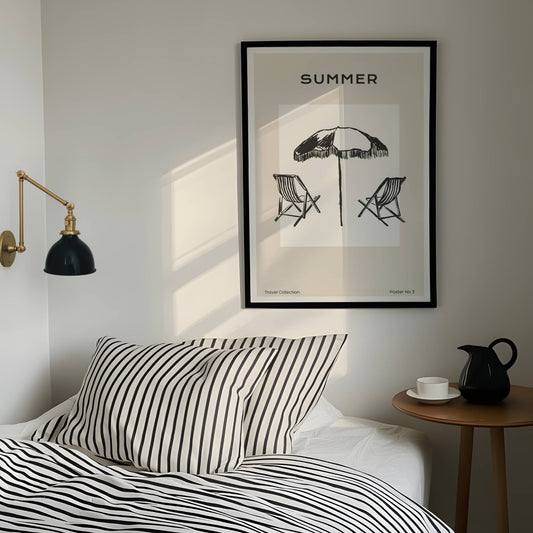 TRAVEL COLLECTION No3 – grafisk plakat er et sommerlig kunsttrykk som viser to klassiske solstoler under en stor parasoll, med teksten SUMMER. Illustrasjon viser plakat i sort ramme.