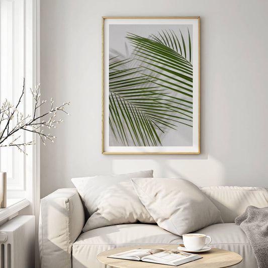 Elegante palmebladene mot en lys bakgrunn skaper en moderne og harmonisk følelse, perfekt for skandinavisk og minimalistisk interiør. Illustrasjon viser motivet som plakat i eik ramme.