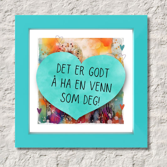 Plakat med turkist hjerte og tekst "Det er godt å ha en venn som deg" - og et motiv med farger i grønn, blått og oransje. Med hvit kant på 1,5 cm. Illustrasjon viser plakat i turkis ramme.